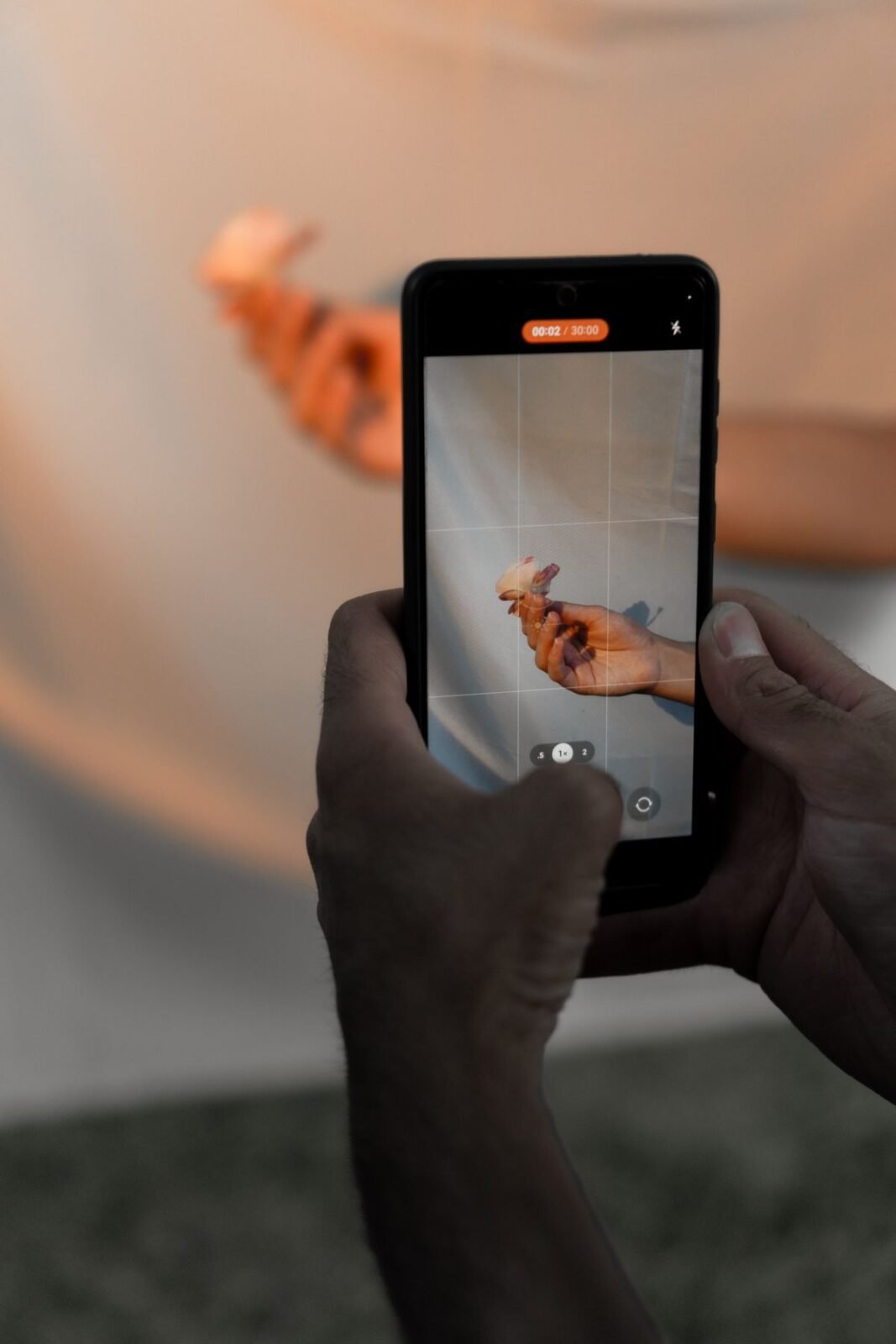 Mãos segurando um smartphone gravando vídeo