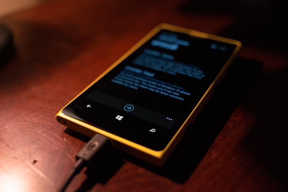 Smartphone com tela acesa em fundo escuro