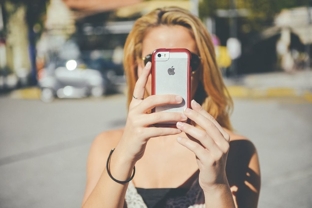 Mulher fotografando com o celular